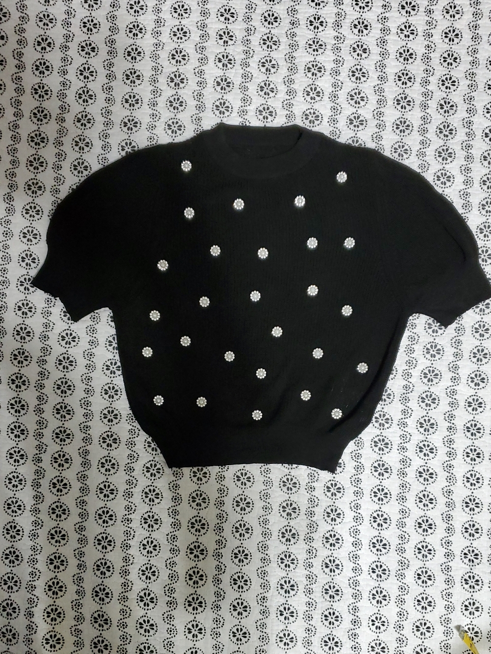 black short-sleeve knit top with pearl and rhinestone embellishments